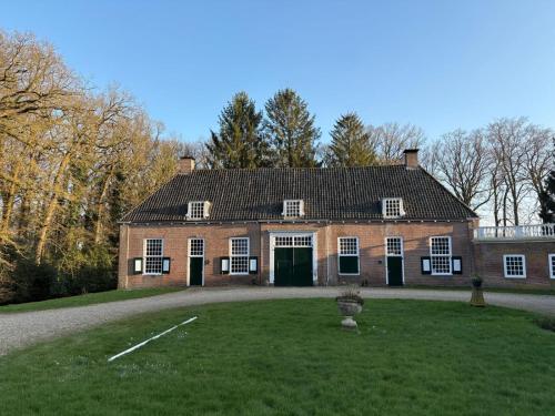 a large brick house with a green yard at De Zwaluwenburg in 't Harde