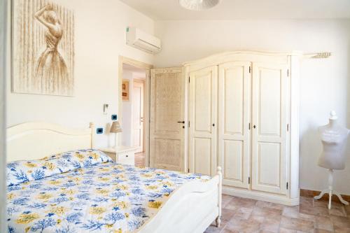 a bedroom with a bed with a blue and white bedspread at Villa Aratza in Orosei