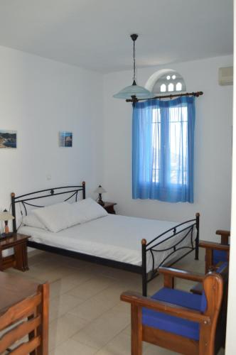 a bedroom with a bed and a blue curtain at Karyatides Houses in Kariá
