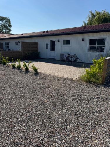 a patio in front of a white building at Bøtø strand ferielejlighed 2 in Marielyst