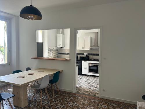 une cuisine avec une table et des chaises en bois dans l'établissement Appartement SUZANNE, à Saint-Cyr-sur-Mer