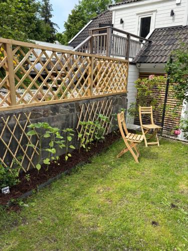 a wooden fence and a chair in a yard at Tiny house in Arendal in Arendal