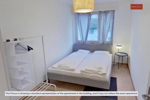 チューリッヒにあるSimple 2BR Apartment with Natural Lightのベッドと窓のある小さな寝室
