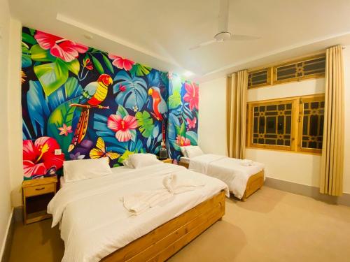a bedroom with two beds and a colorful wall at Askari Inn Hotels in Swat