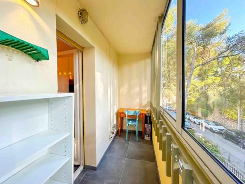 Cette chambre dispose d'une fenêtre avec une table et une chaise. dans l'établissement T3 Sanary avec garage proche centre ville, à Sanary-sur-Mer