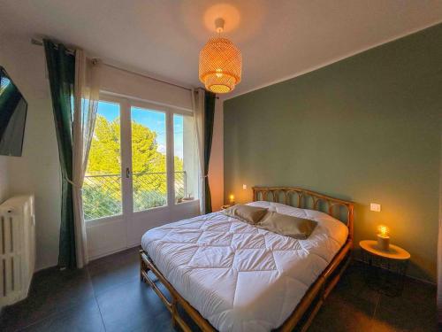 une chambre avec un lit et une grande fenêtre dans l'établissement T3 Sanary avec garage proche centre ville, à Sanary-sur-Mer