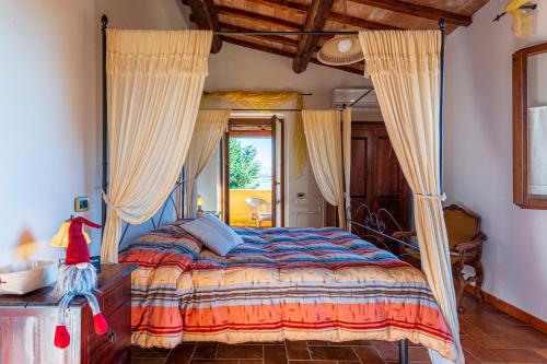 a bedroom with a large bed with curtains on it at La Casa di Gelsomino in Massa Martana
