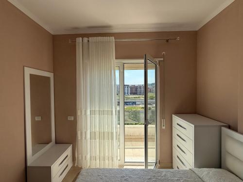 a bedroom with a bed and a sliding glass door at Sani Apartment in Golem