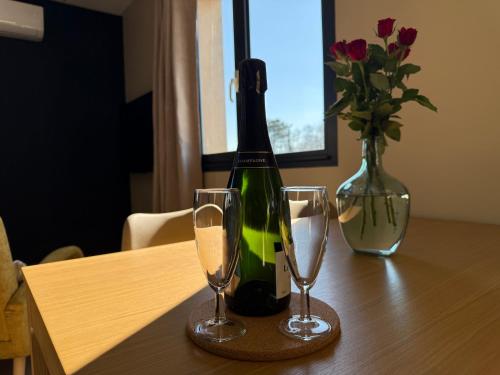 une bouteille de vin et deux verres sur une table dans l'établissement Suite du Spa 2 - Parking Privé Gratuit, à Reims
