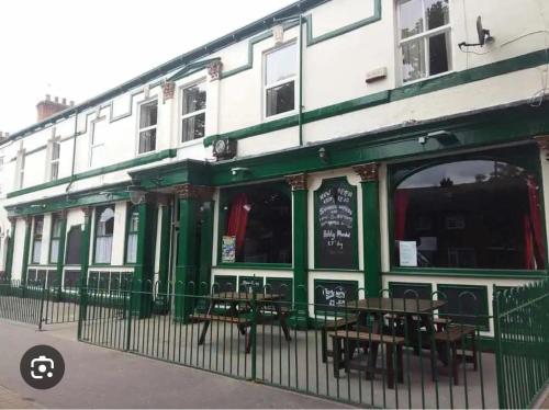 a green and white building with tables in front of it at St Georges Hotel in Hull