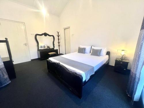 a bedroom with a bed and a large mirror at Lavender Villas Nuwara Eliya in Nuwara Eliya