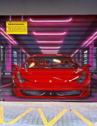 a red car is parked in a garage at NAVA Apartment in the center with private parking of stayinthess in Thessaloniki