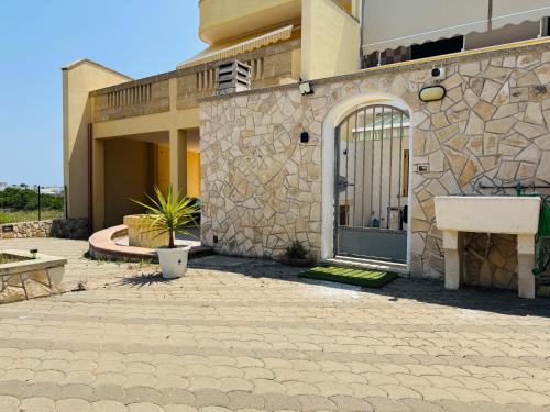 a stone building with a door and a patio at casa in spiaggia in Marina di Pescoluse