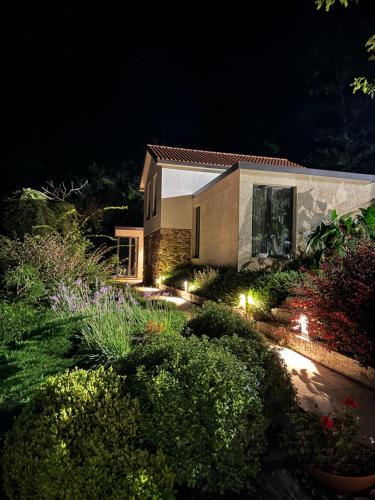 a house with lights in a garden at night at Eira Gundián in Vedra