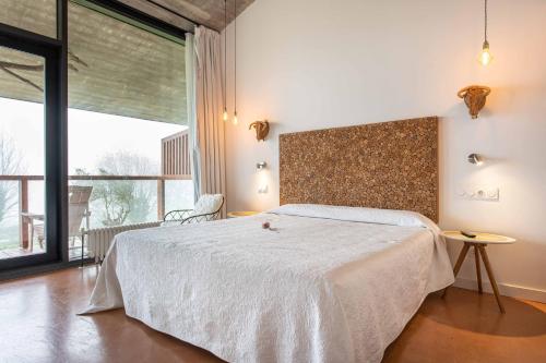 a bedroom with a bed and a large window at Niditas Suites & Horses in Santillana del Mar