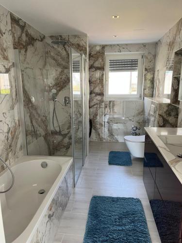a bathroom with a tub and a toilet and a sink at Lakeside, awesome & romantic, with stylish design in Reichenau