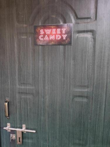 a sign on a door that sayssweet candy at Cozy Nest in Guwahati