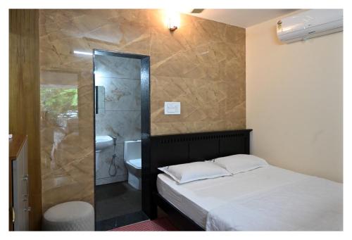 a bedroom with a bed and a bathroom with a shower at Atithi Homestay, Udupi in Udupi
