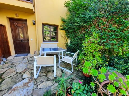 a patio with a table and chairs next to a building at VIVIENDAS RURALES LAS CALDERAS in Santillana del Mar