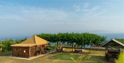 a small house in a yard with trees in the background at Artsy Wooden Cottage in Ratzaklíon