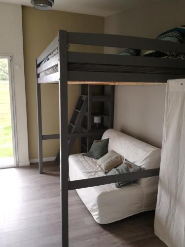 Ce lit superposé se trouve dans un dortoir doté d'un canapé. dans l'établissement Pause detente dans le golfe du morbihan, à Auray