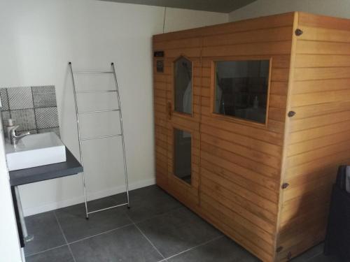 a bathroom with a sink and a wooden wall at Pause detente dans le golfe du morbihan in Auray