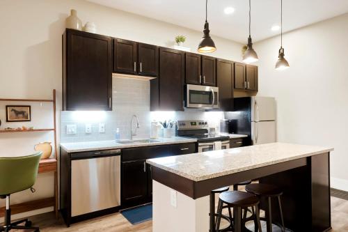 a kitchen with black cabinets and a kitchen island with bar stools at Unbeatable Location Golden Condo - Walk Everywhere in Golden