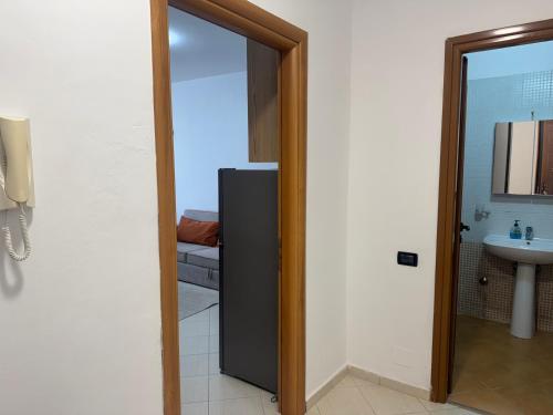 a door to a bathroom with a sink and a refrigerator at Orkidea Apartments 2 in Golem