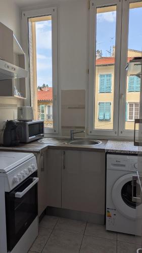 une cuisine avec un évier et une machine à laver dans l'établissement Appartement - Nice - Quartier du Port, à Nice