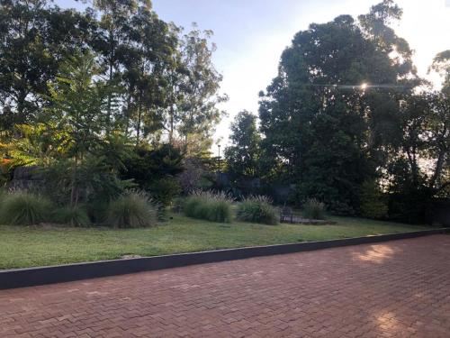 a brick path in a garden with trees and grass at Eastern Road Executive Suites in Harare