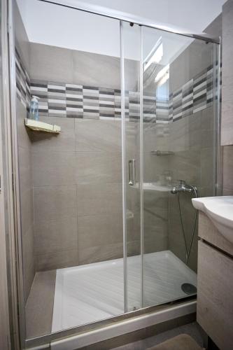 a shower with a glass door in a bathroom at Thea Apartment 3 in Emporeios
