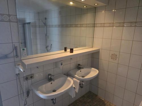 a bathroom with two sinks and a mirror at Ferienwohnung Allgäu 134 in Wiggensbach
