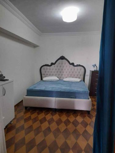 a bedroom with a bed with a blue comforter at Park View Apartment Batumi in Batumi