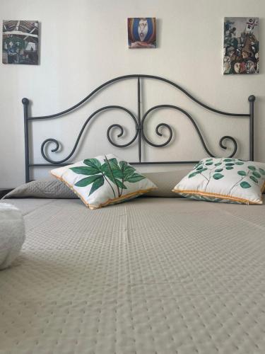 a large bed with a metal headboard and two pillows at Maison Linda in Santa Teresa Gallura