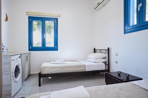 a room with two beds and a washing machine at Thea Apartment 3 in Emporeios