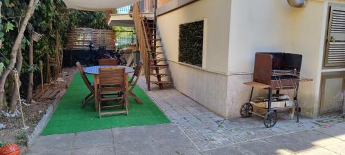 a room with a table and chairs on a green rug at Aurora sul mare in Terracina