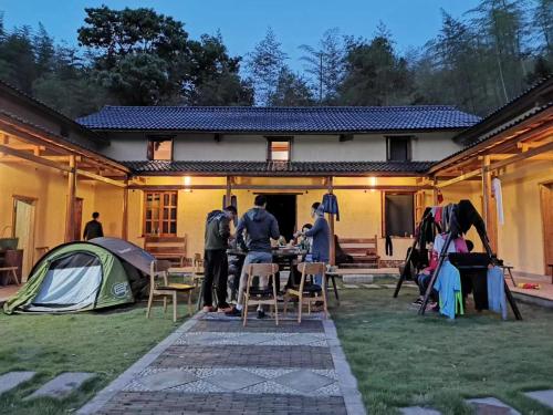 a group of people standing outside of a house with a tent at Zhejiang Anji Xiaoshe B&B Near Zhejiang North Grand Canyon Deep Creek Canyon Rafting Jiangjunguan Rafting Wind Paragliding Zhangli Ancient Road Longwangshan Scenic Area in Shangzhang