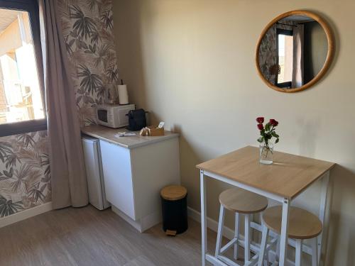 una pequeña cocina con mesa y espejo en Suite du Spa 3 - Parking Privé Gratuit, en Reims