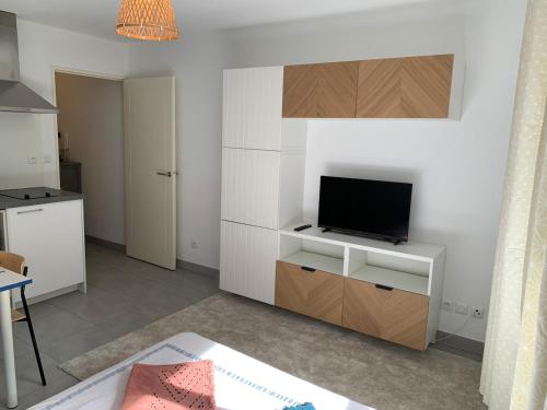 - un salon avec une télévision sur un meuble blanc dans l'établissement Joli studio, quartier du port, à Nice