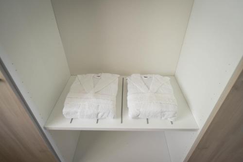 two towels on a white shelf in a bathroom at ETNAGLOW Luxory Sicilian Villa in Nicolosi