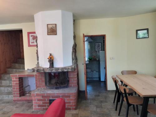 a living room with a brick fireplace and a table at Apartament nad jeziorem in Małe Swornegacie
