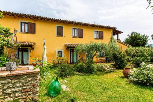 a yellow house with a yard in front of it at La Casa di Gelsomino in Massa Martana