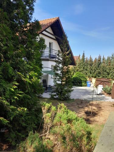 a white house with a gambrel roof at Apartament nad jeziorem in Małe Swornegacie