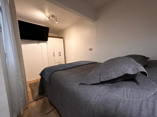 a bedroom with a bed and a flat screen tv at Casona Lorena in Santiago