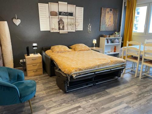 une chambre avec un lit, une table et des chaises dans l'établissement Appartement Lumineux avec Parking Privée, à Ban-Saint-Martin