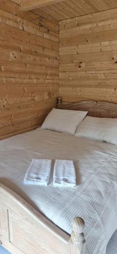 a bedroom with a bed with two towels on it at Vila Skodupė 