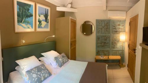- une chambre avec un lit doté d'une tête de lit verte dans l'établissement La Vagabonde, à Saint-Tropez