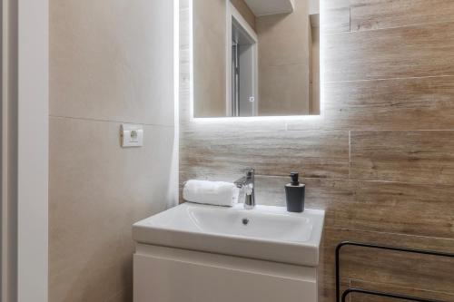 ein Badezimmer mit einem weißen Waschbecken und einem Spiegel in der Unterkunft Up Above at Waterview Collection in Oradea