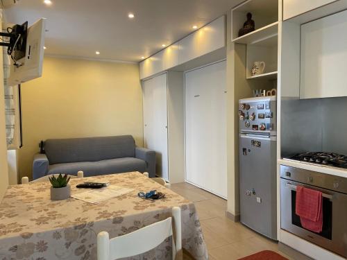 a kitchen with a table and a couch in a room at Casa Sermoneta in Naples