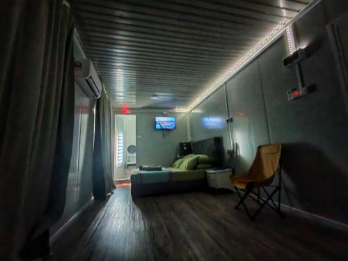 a bedroom with a bed and a chair in a room at Roemah Kabin PakNgah at Inapan Keluarga Jitu in Jitra